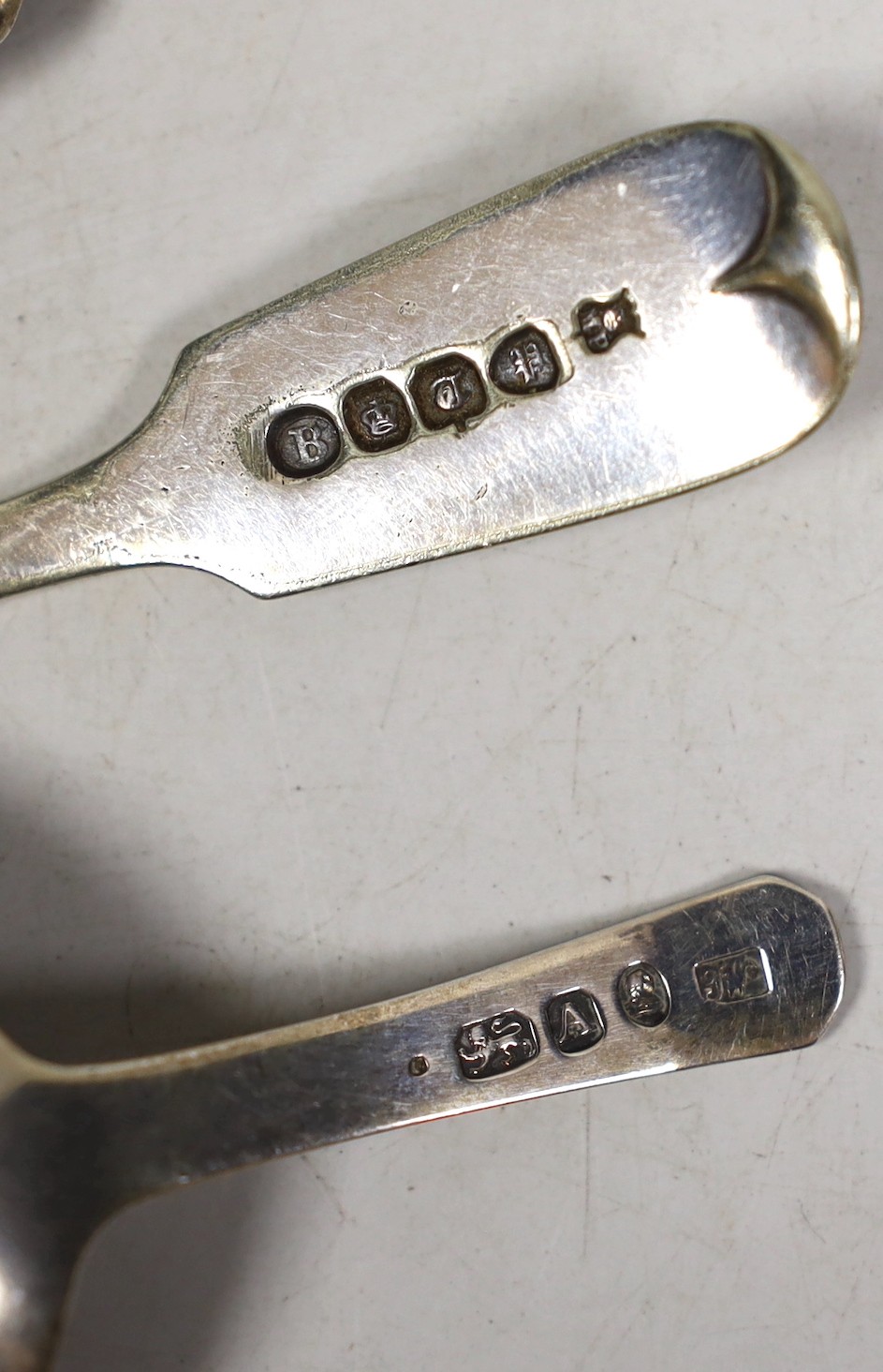 Three silver caddy spoons, including two 19th century, a silver infuser, a sifter spoon, a cheese knife and a plated condiment spoon.